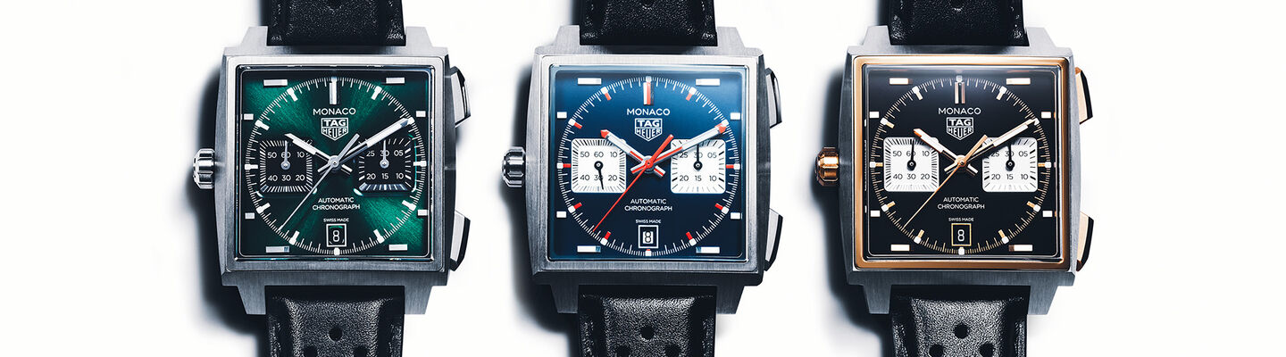 Three TAG Heuer Monaco chronograph watches with perforated black leather straps, shown side by side in green, blue, and black dial variations with square cases.